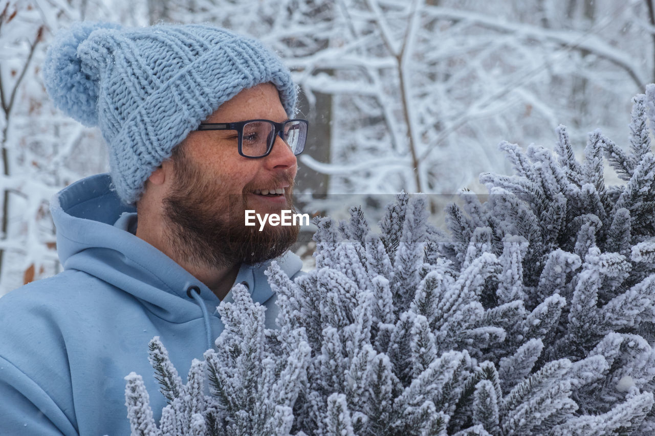 portrait of young man looking away against trees