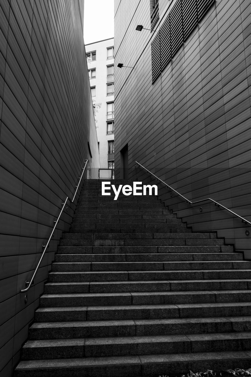 Low angle view of staircase amidst buildings in city