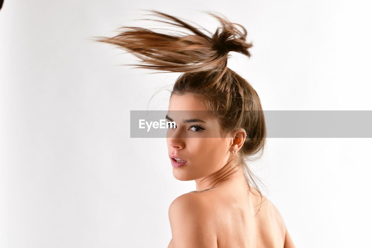 Portrait of young woman against white background