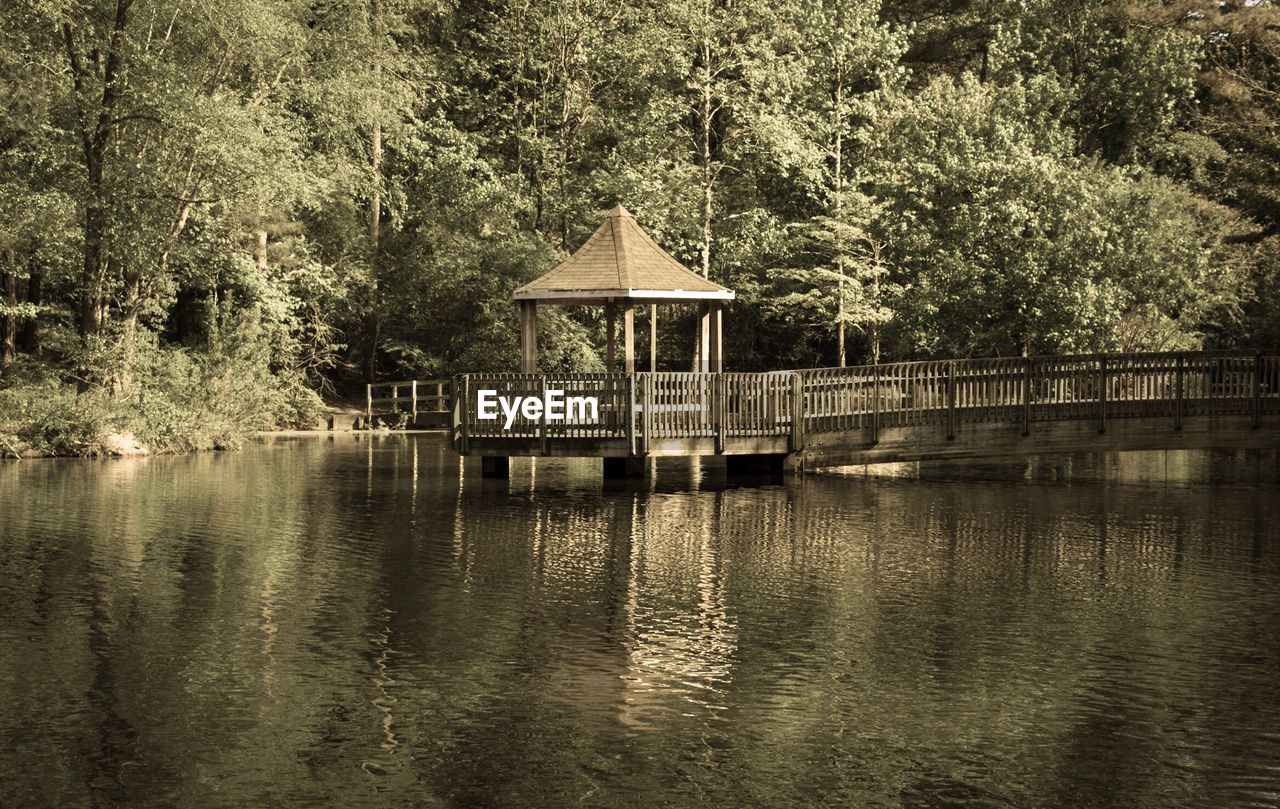 BUILT STRUCTURE BY LAKE AGAINST TREES