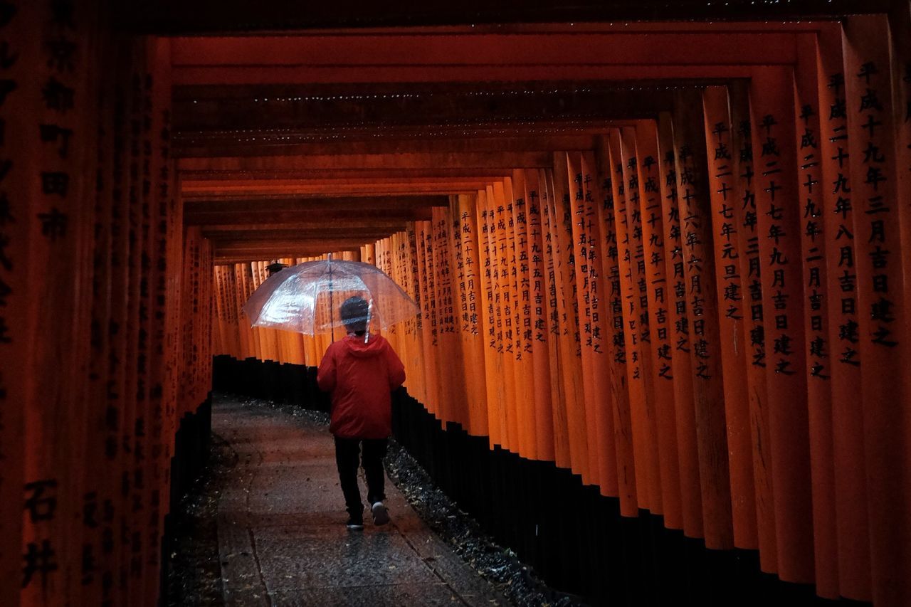 FULL LENGTH OF WOMAN STANDING BY ILLUMINATED BUILDING