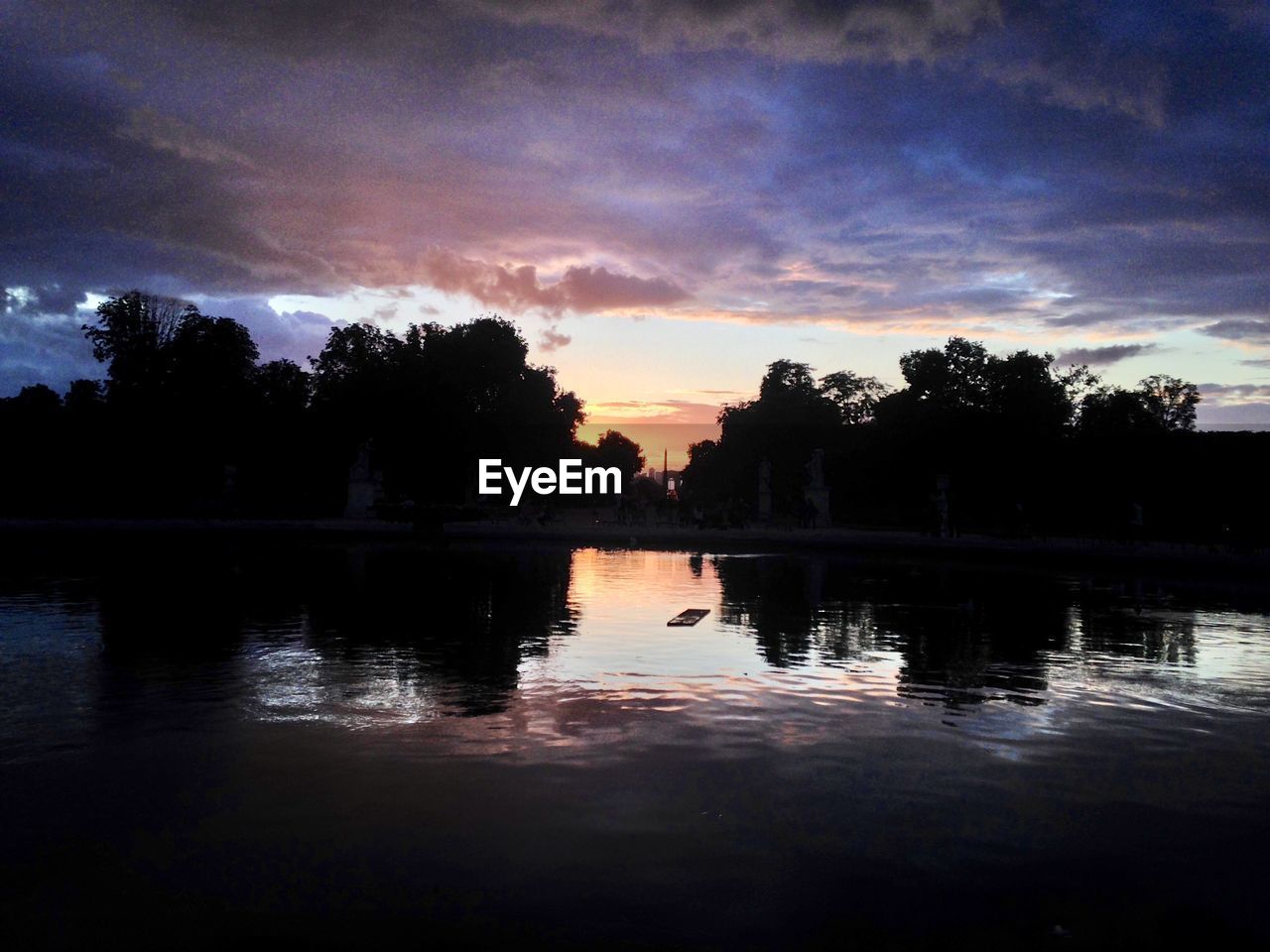 SILHOUETTE TREES BY LAKE AGAINST SKY AT SUNSET