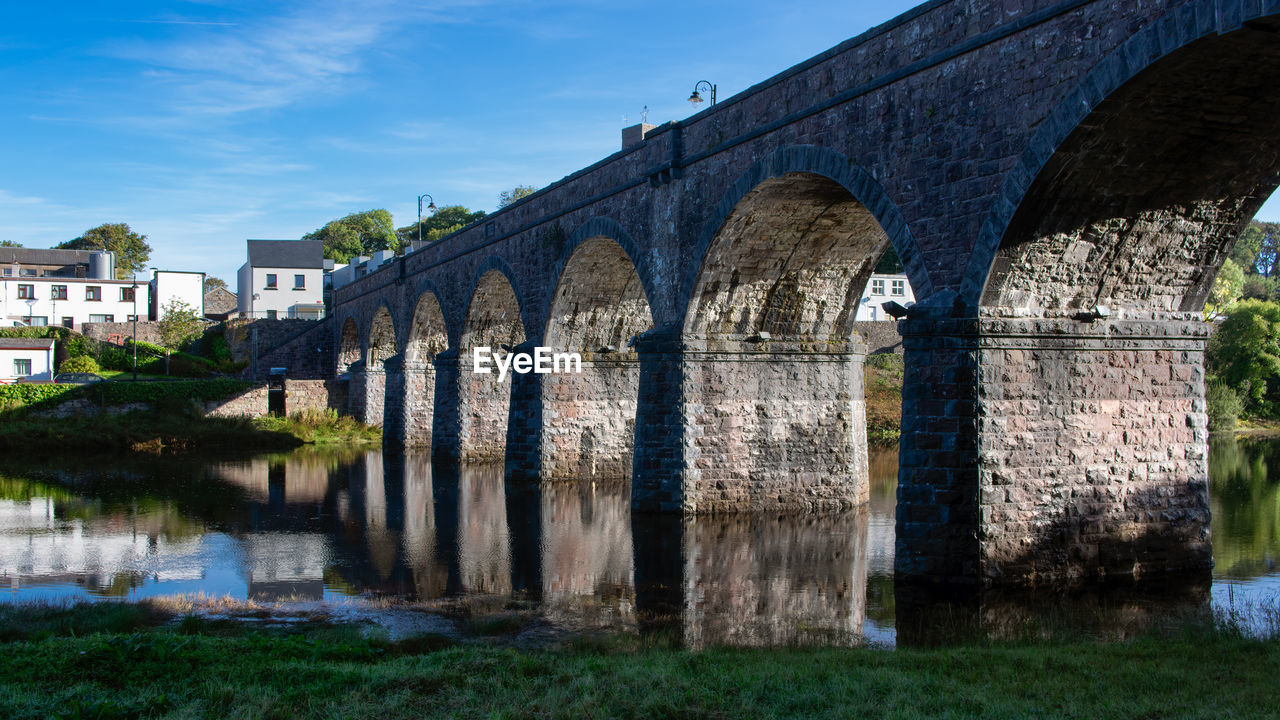 ARCH BRIDGE OVER OLD BUILDING AGAINST SKY