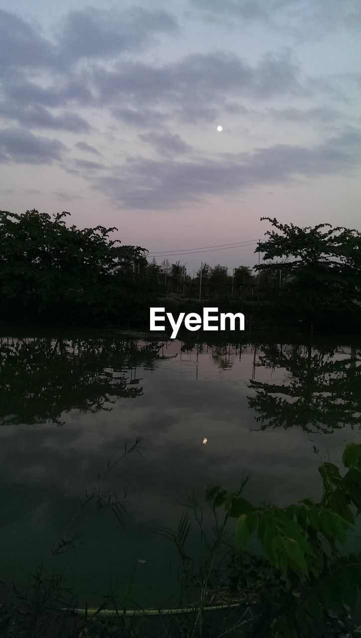 Scenic view of calm lake against cloudy sky