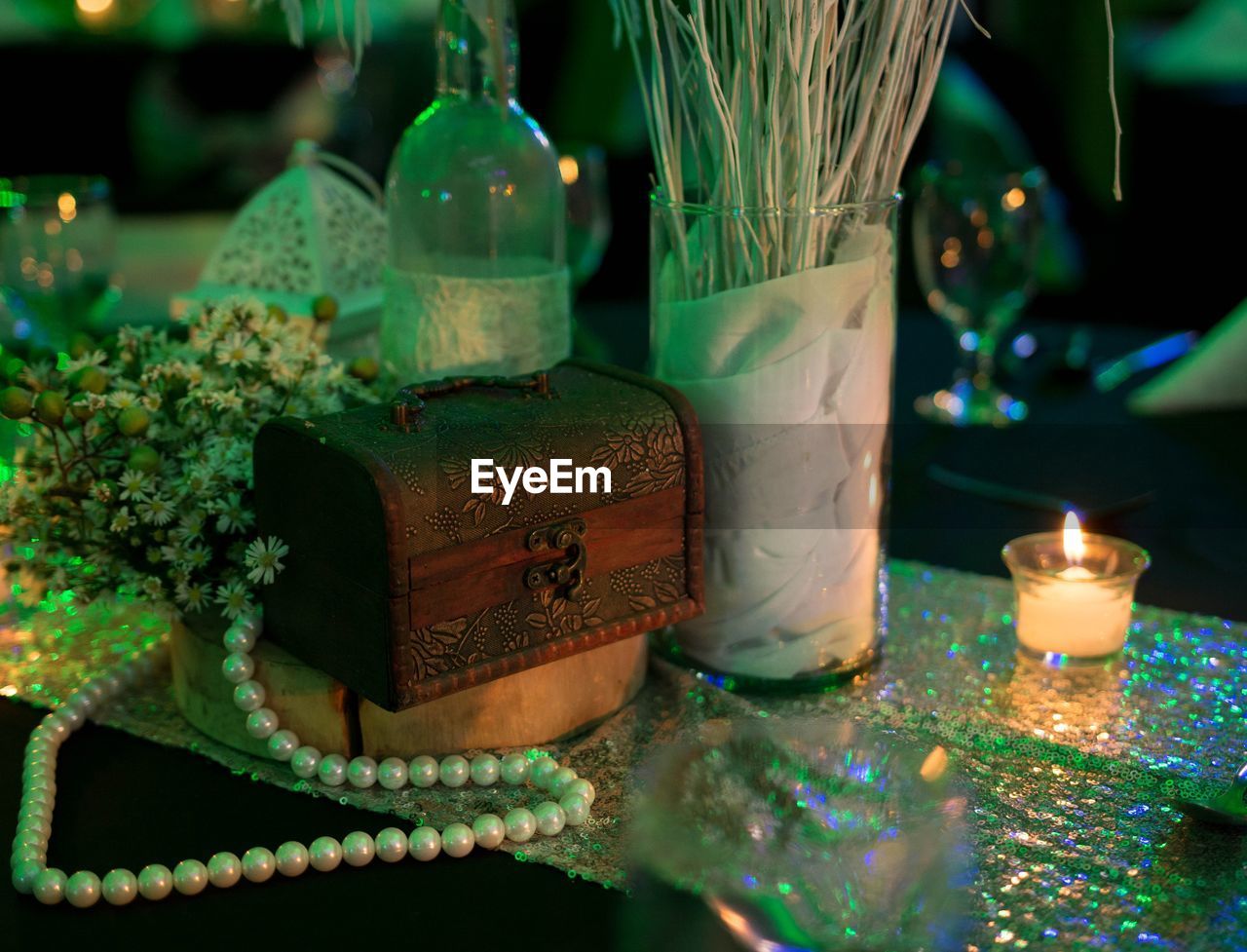 Close-up of illuminated diya by christmas decorations on table