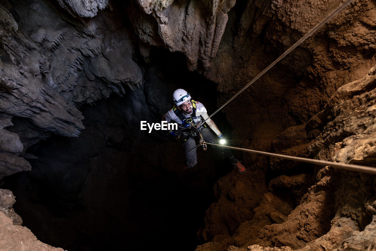 View from above of a man doing caving