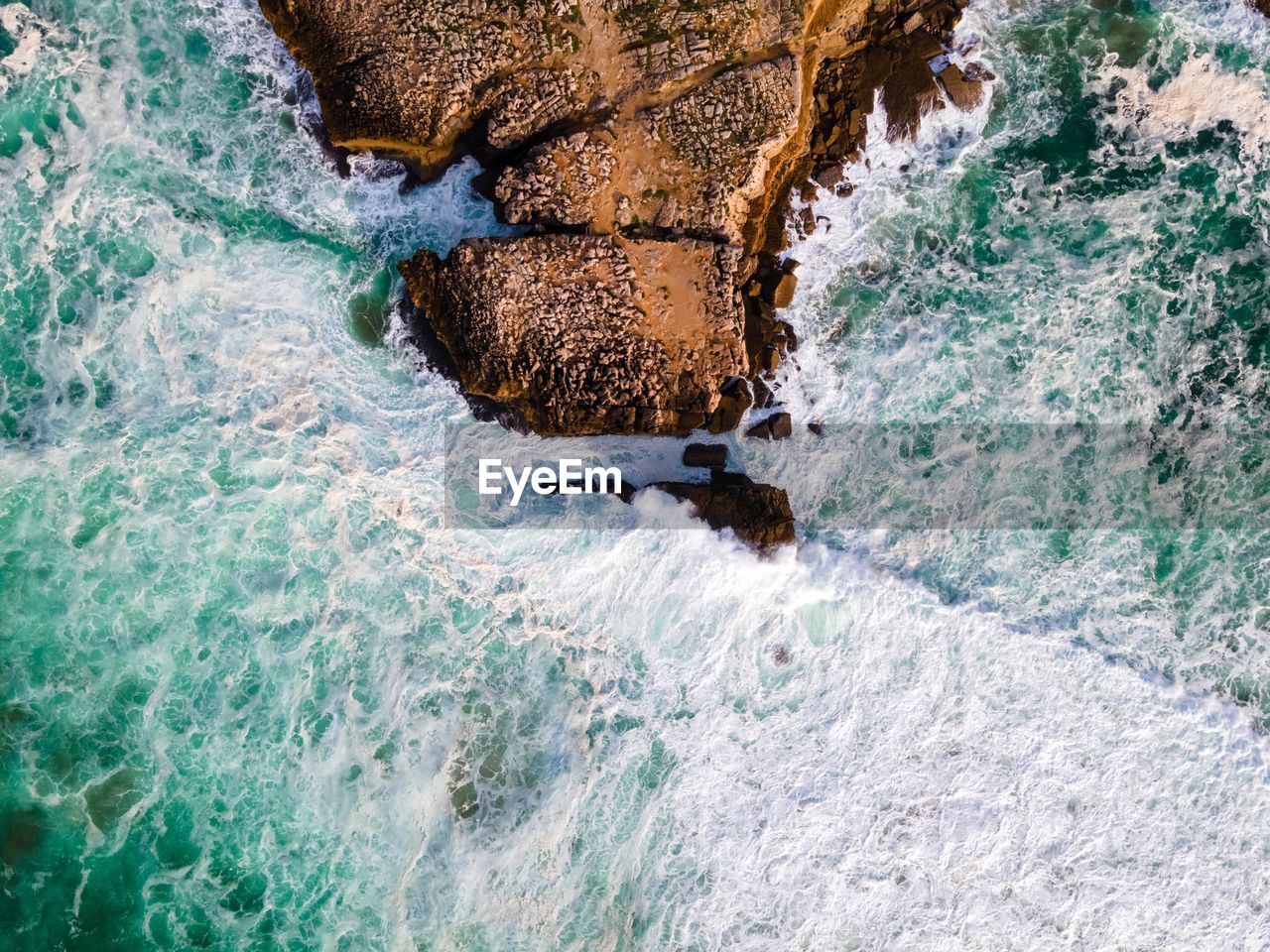 HIGH ANGLE VIEW OF ROCKS ON SEA