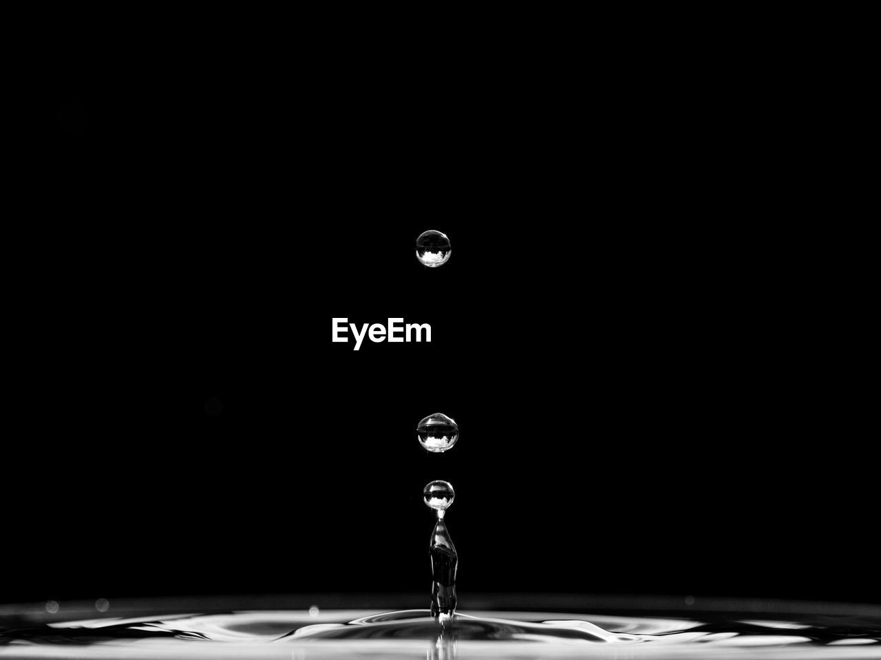 Close-up of water drop splashing against black background