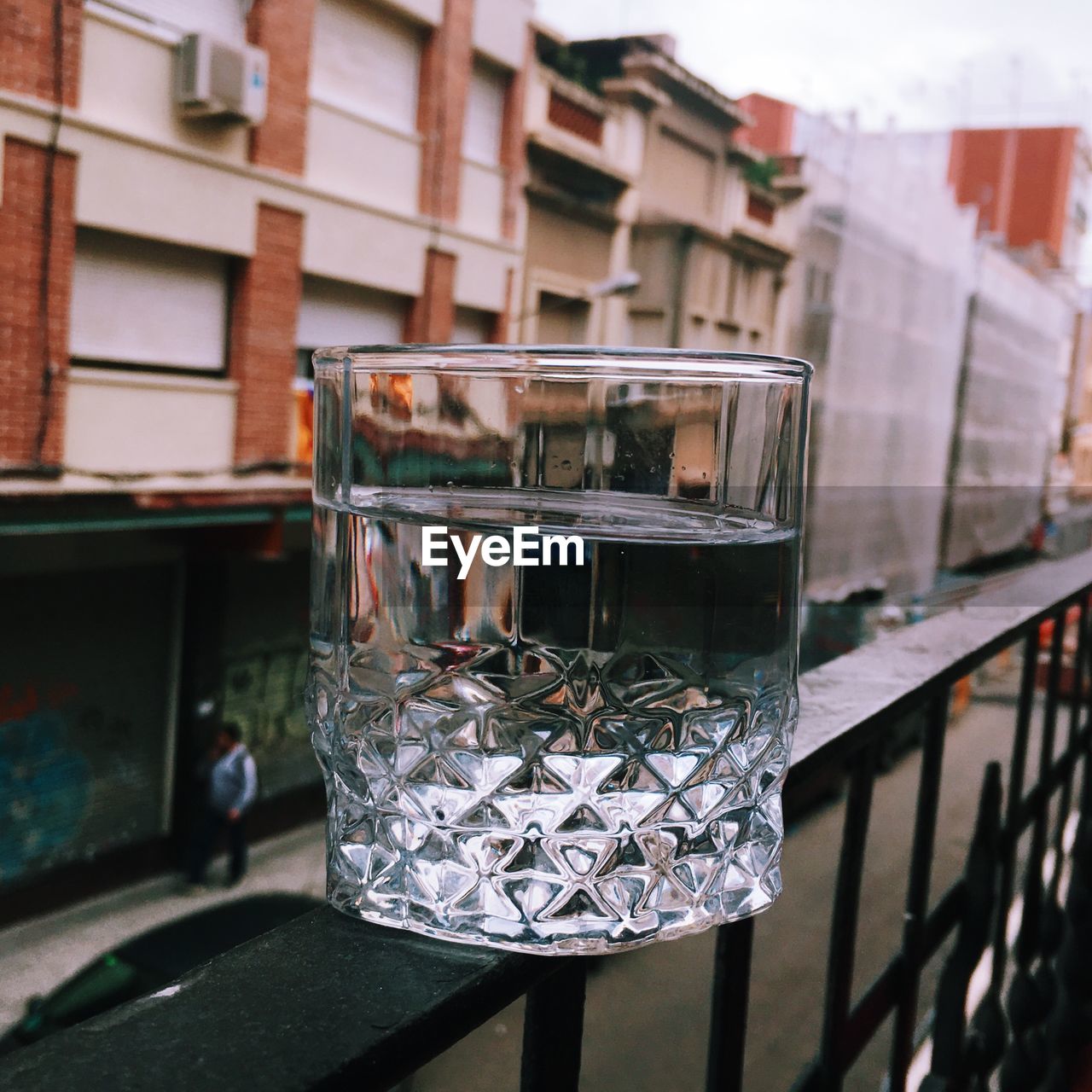 Glass of water on the railing of a balcony