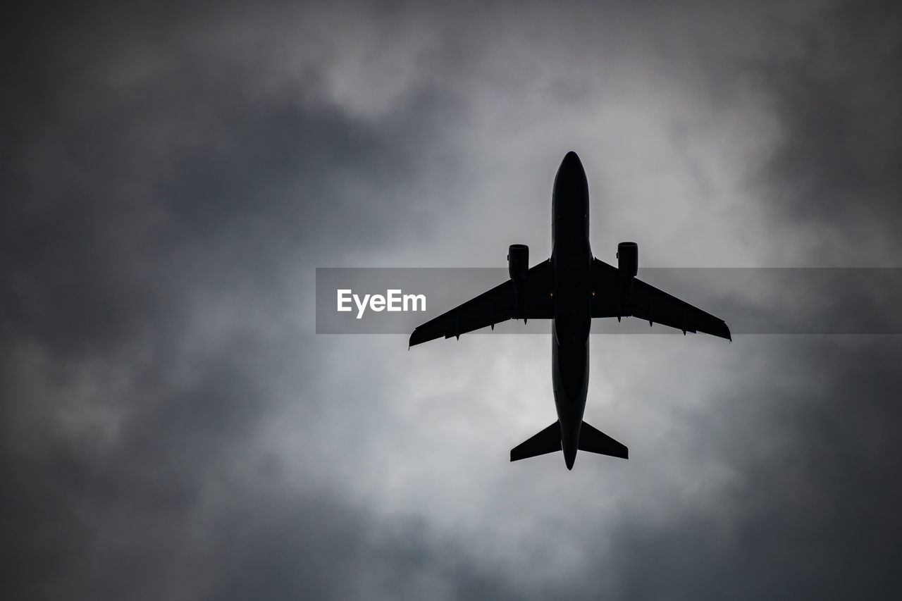 LOW ANGLE VIEW OF SILHOUETTE AIRPLANE IN SKY