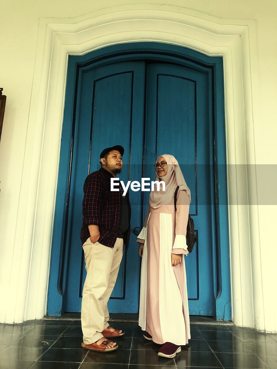 Couple standing by door of building
