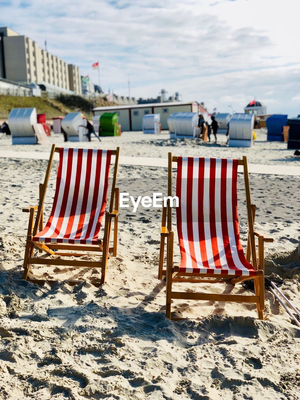 Empty chairs at beach against sky