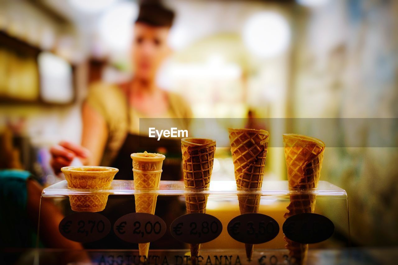 Woman with ice cream cones in glass container