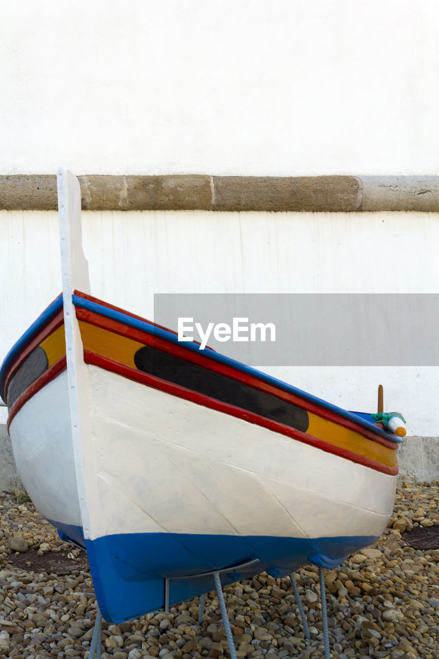 BOAT MOORED ON SHORE