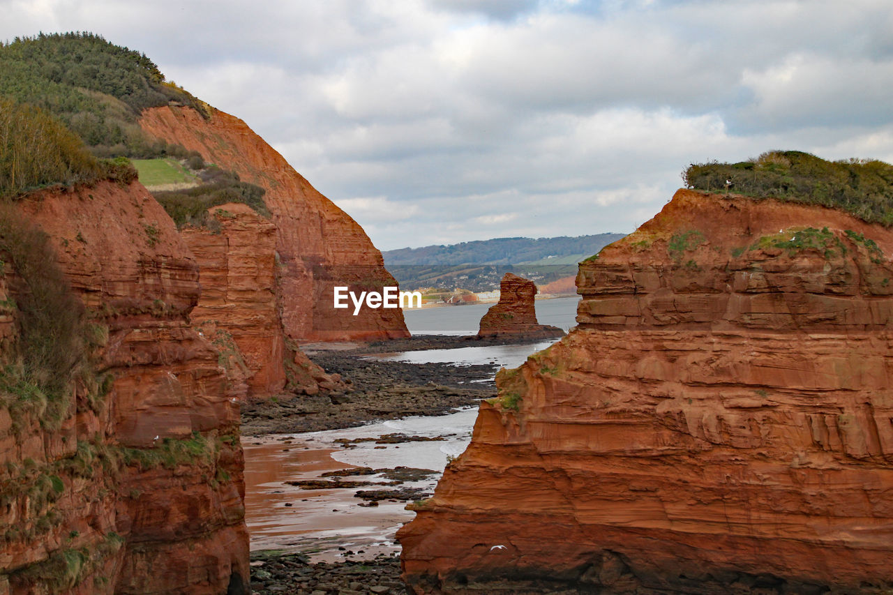 View of rock formations against cloudy sky