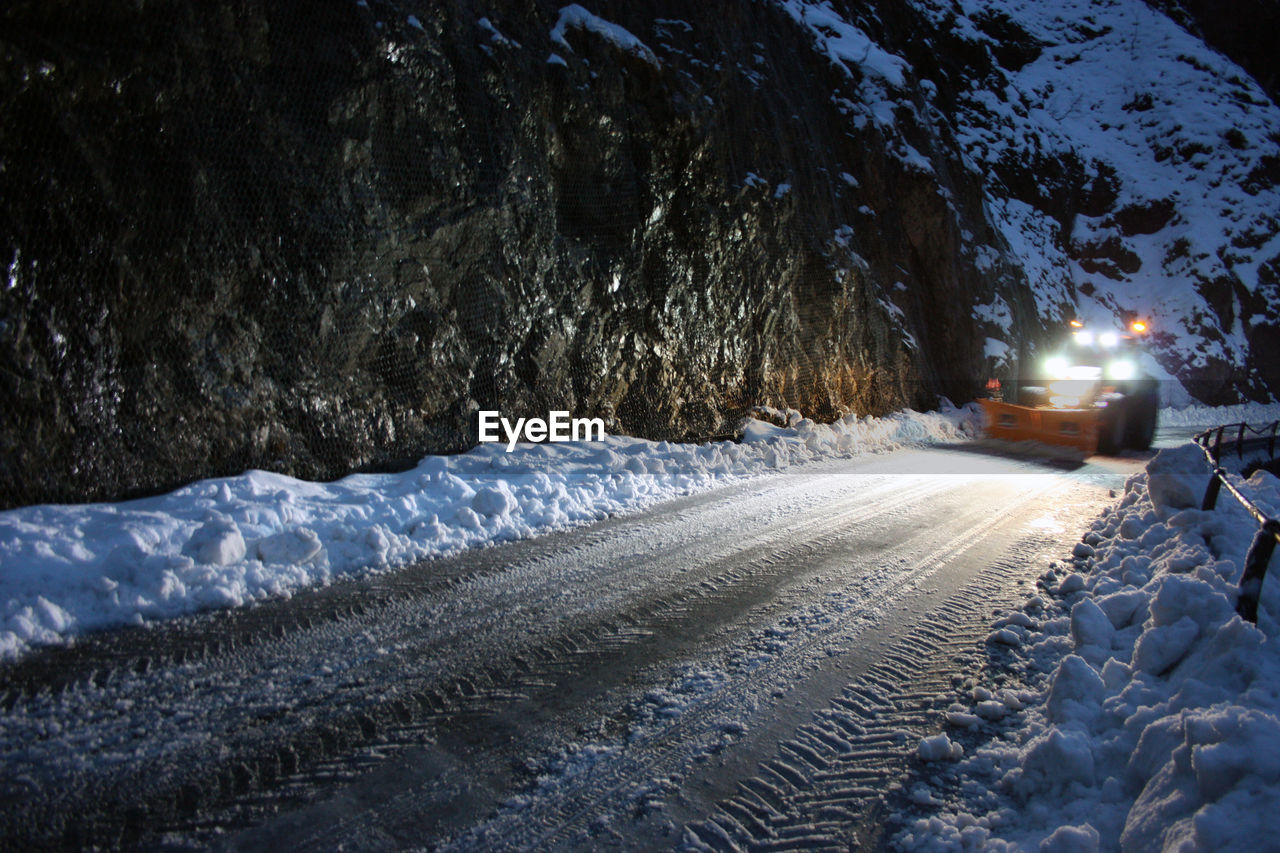 VIEW OF SNOW COVERED ROAD AT NIGHT