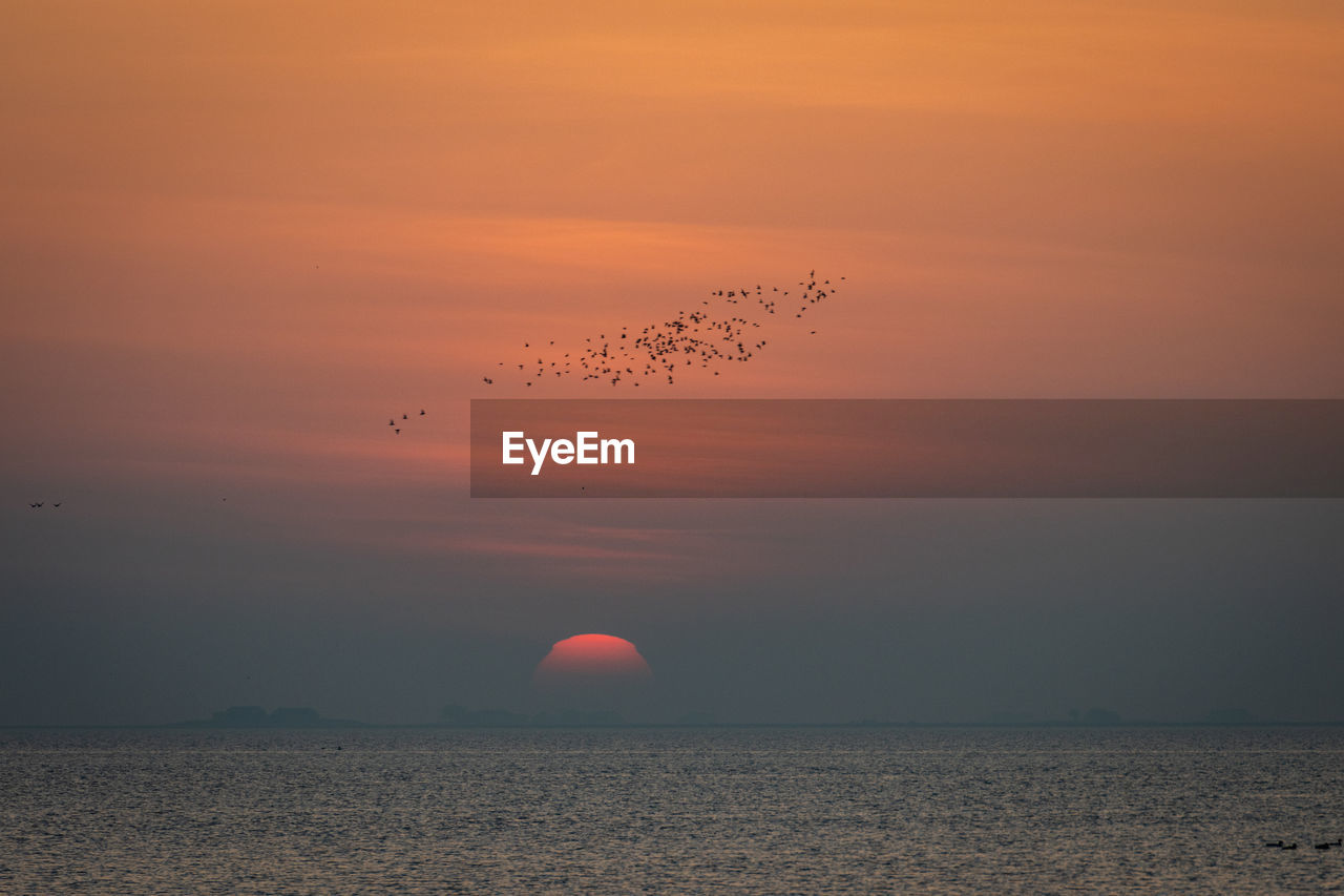 SCENIC VIEW OF SEA AGAINST SKY AT SUNSET