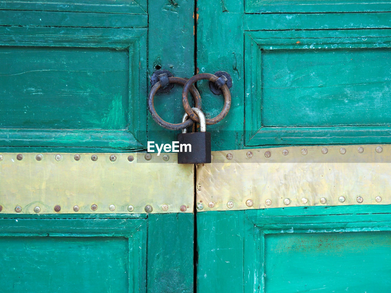 Padlock in rusty rings on door