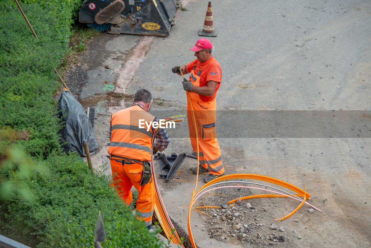 HIGH ANGLE VIEW OF MAN WORKING IN ORANGE