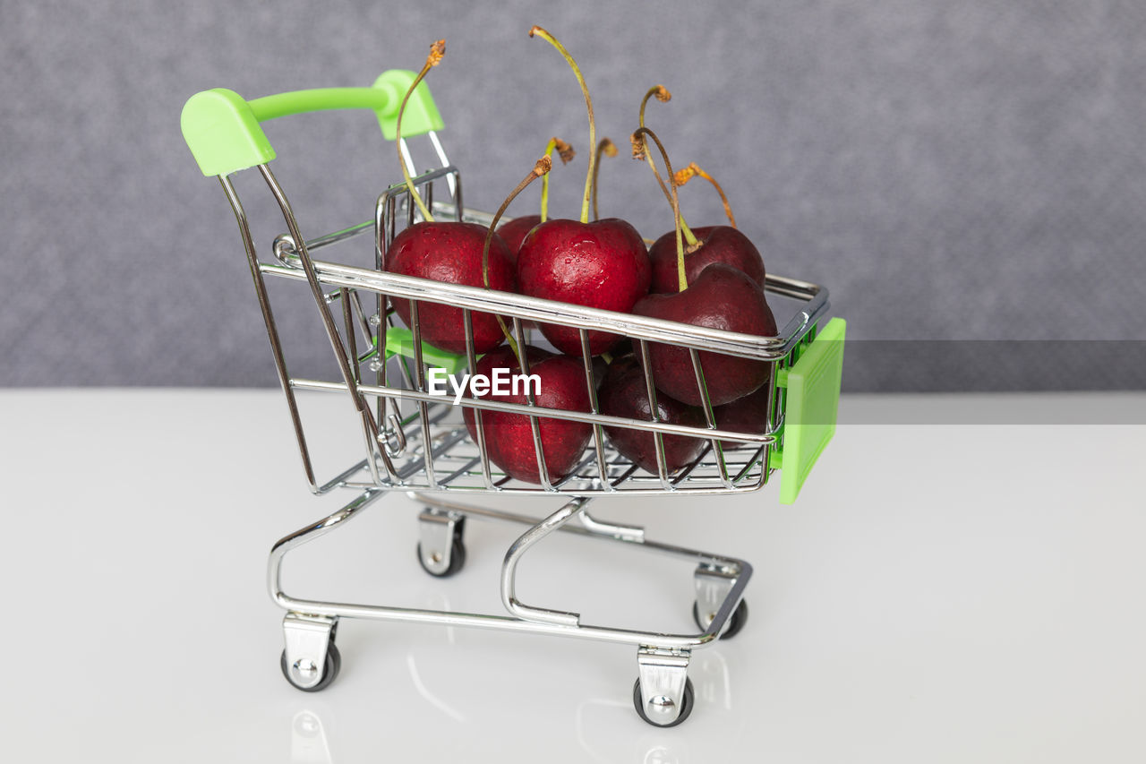 CLOSE-UP OF STRAWBERRIES IN BASKET ON TABLE