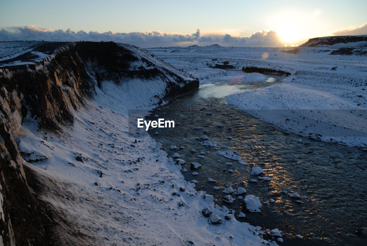 Scenic view of frozen sea against sky during sunset