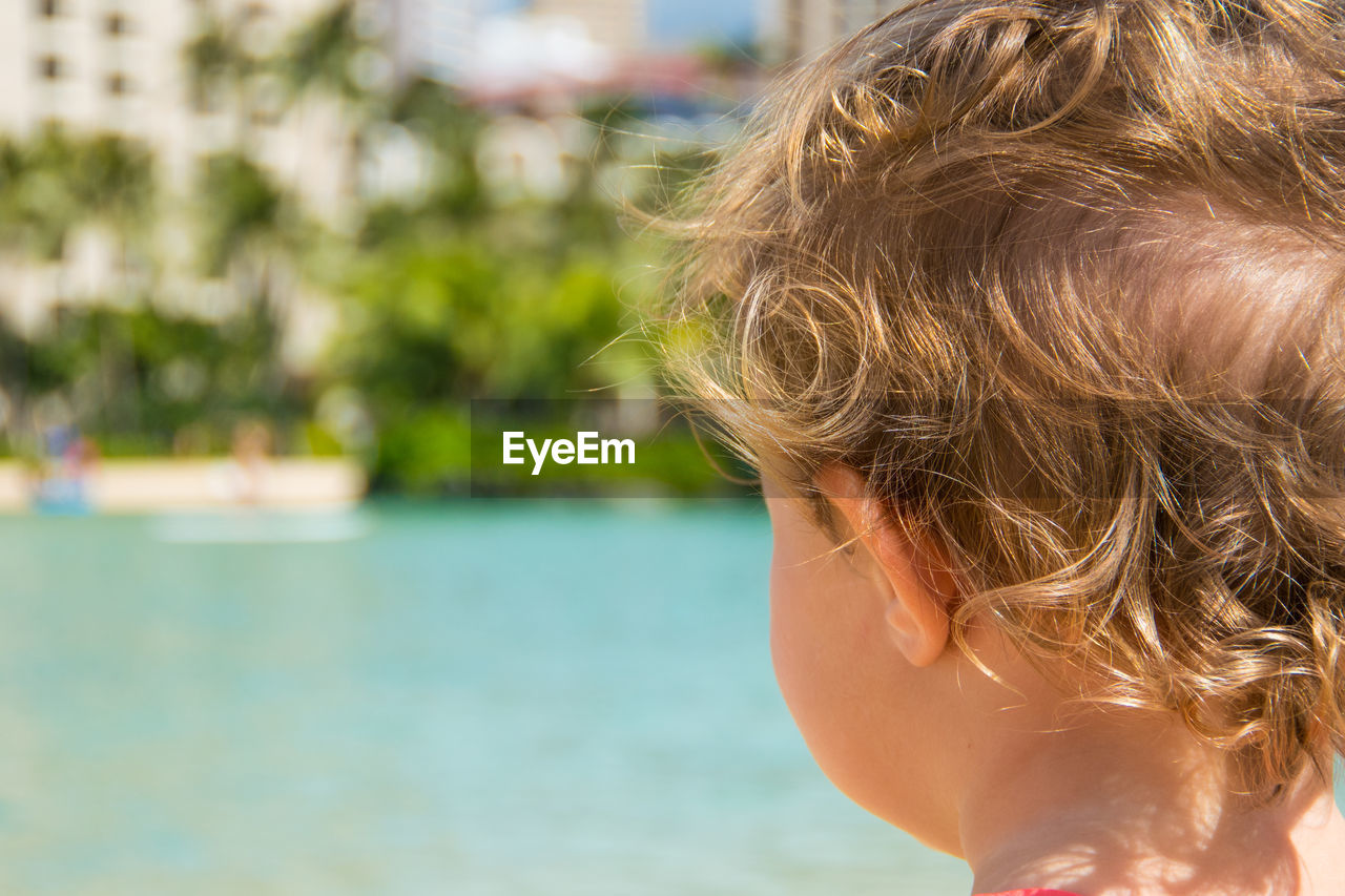 Rear view of boy standing against sea