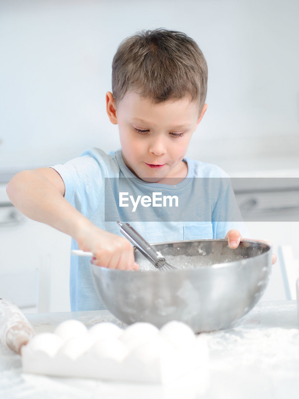 portrait of cute baby boy eating food in bowl on table