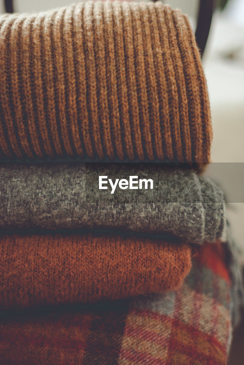 Close-up of sweaters stacked at home