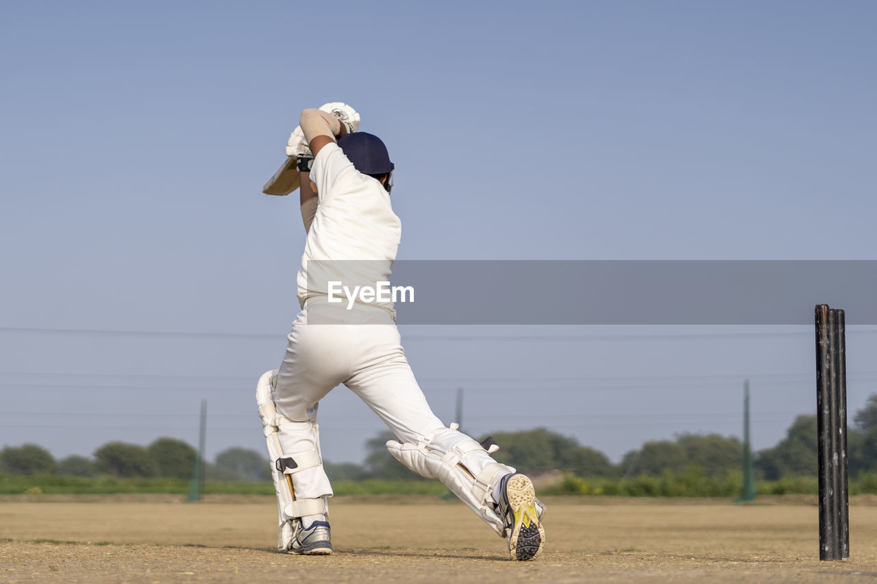sports, one person, ball game, full length, motion, baseball, day, team sport, clothing, sky, leisure activity, adult, nature, activity, baseball player, standing, pitch, outdoors, lifestyles, sports clothing, playing field, athlete, clear sky, baseball uniform