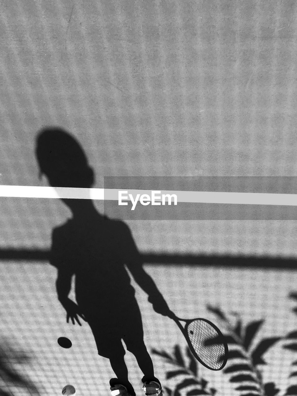 Shadow of a boy playing tennis