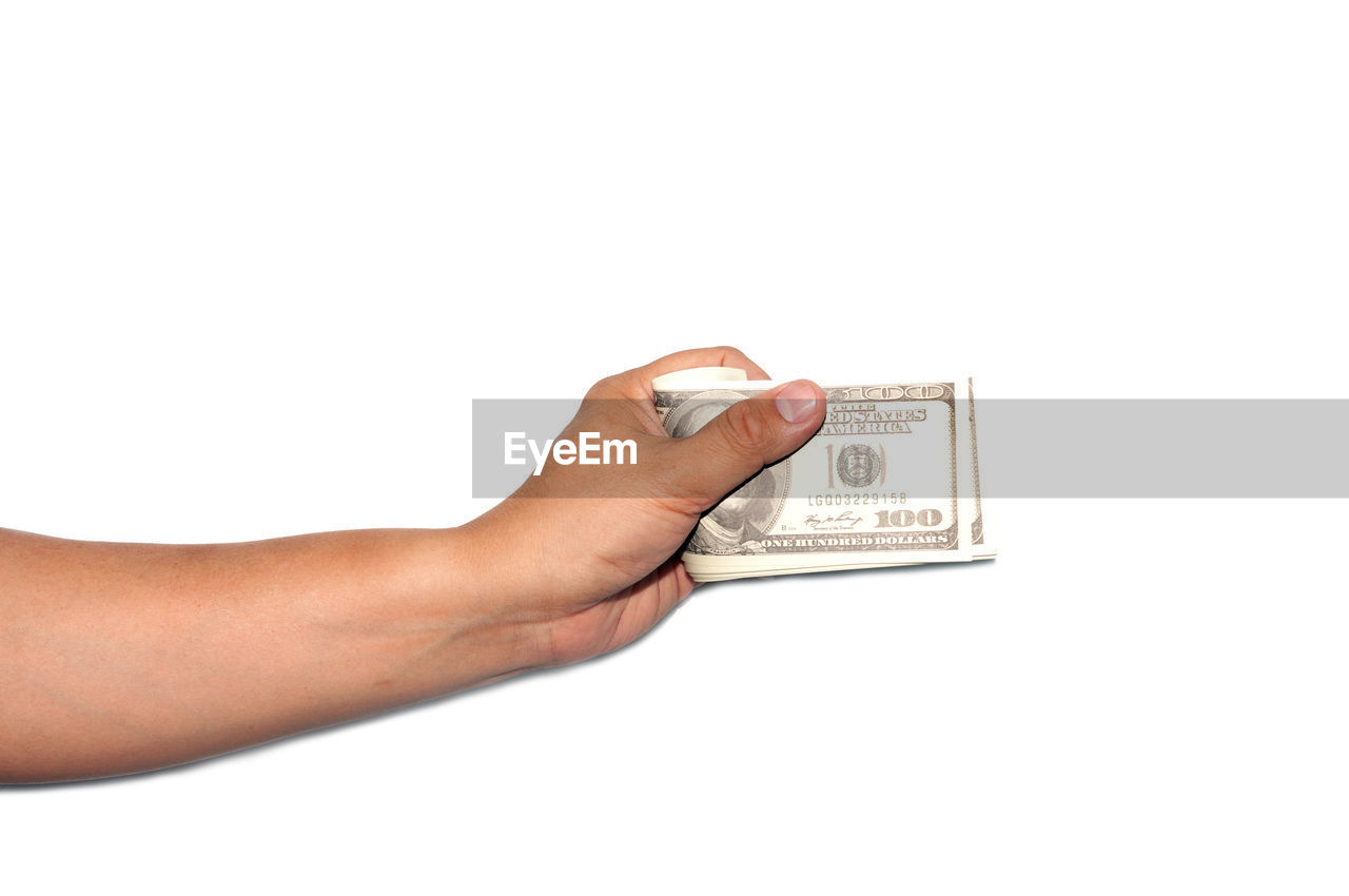 CLOSE-UP OF HAND HOLDING PAPER AGAINST WHITE BACKGROUND