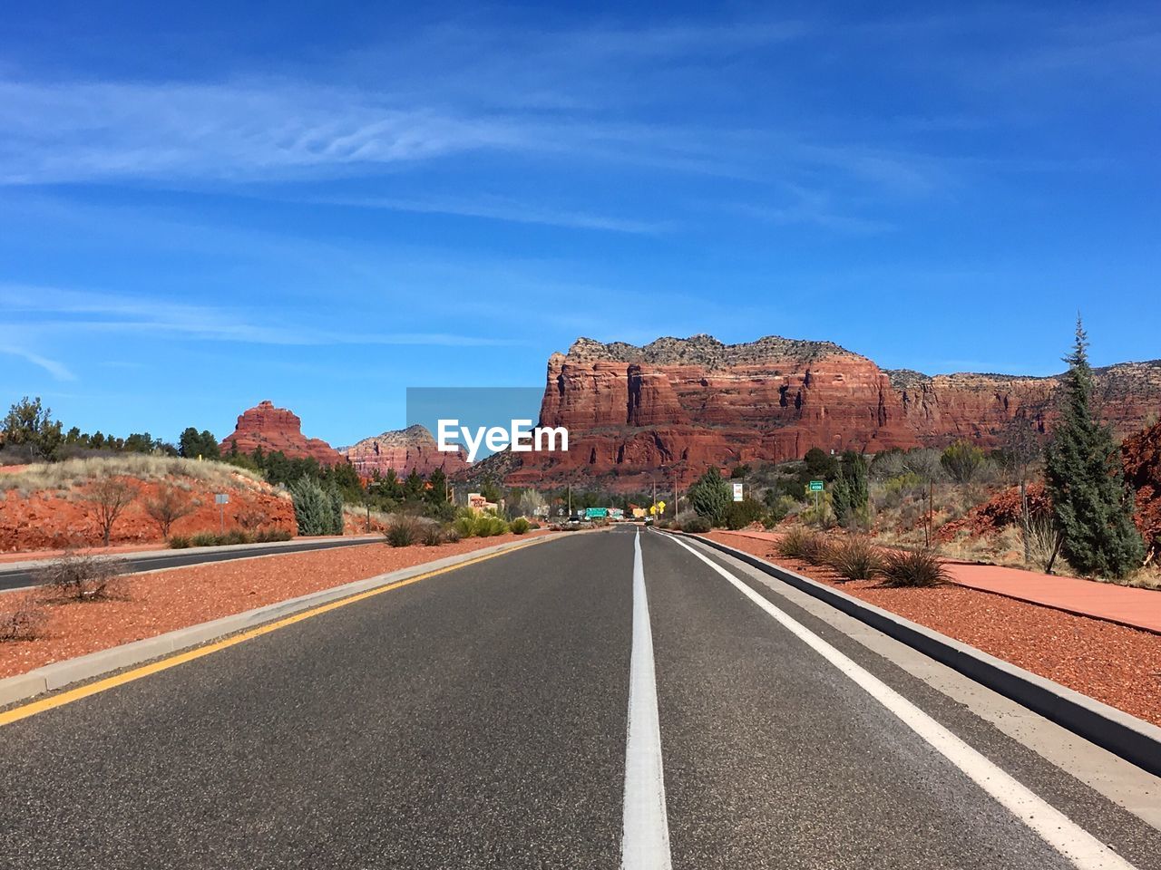 Road by landscape against sky