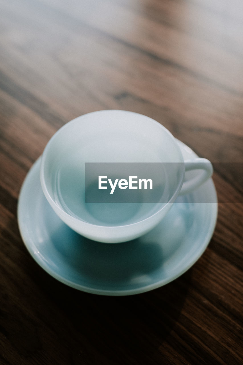 HIGH ANGLE VIEW OF EMPTY COFFEE CUP WITH SPOON ON TABLE