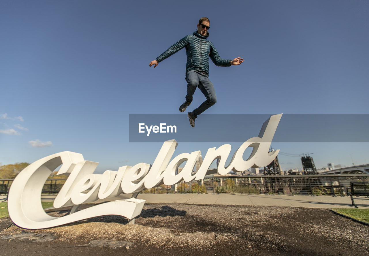 Man in down jacket leaps jumps of cleveland sign, ohio
