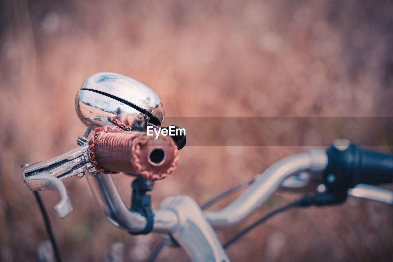 Close-up of a vintage metallic bicycle bell in countryside environment. warm colors