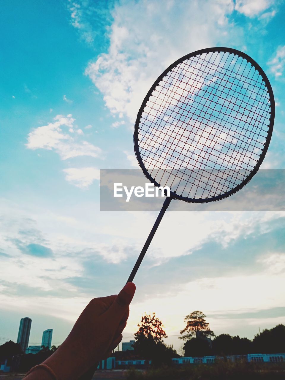 LOW ANGLE VIEW OF PERSON HAND HOLDING UMBRELLA AGAINST SKY