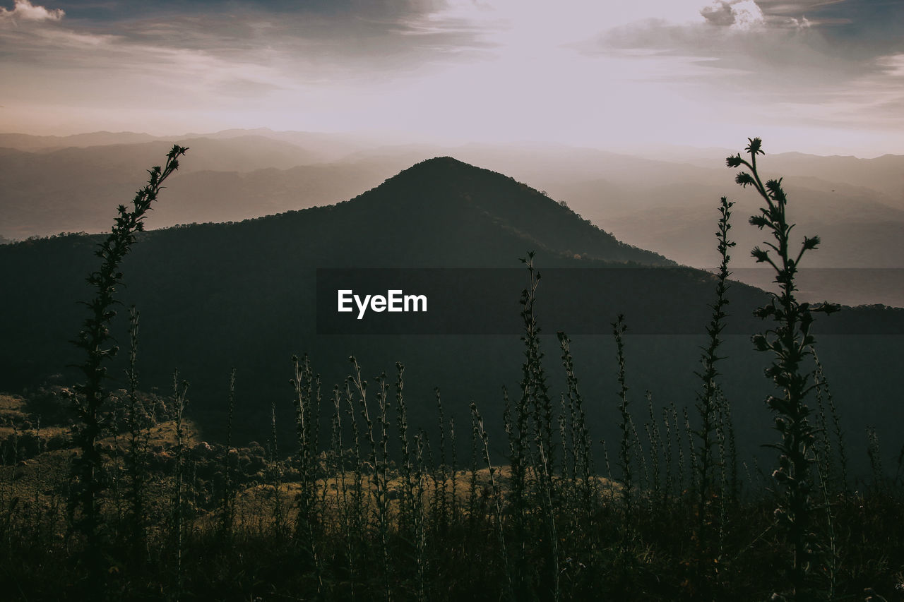 SCENIC VIEW OF MOUNTAINS AGAINST SKY AT SUNSET