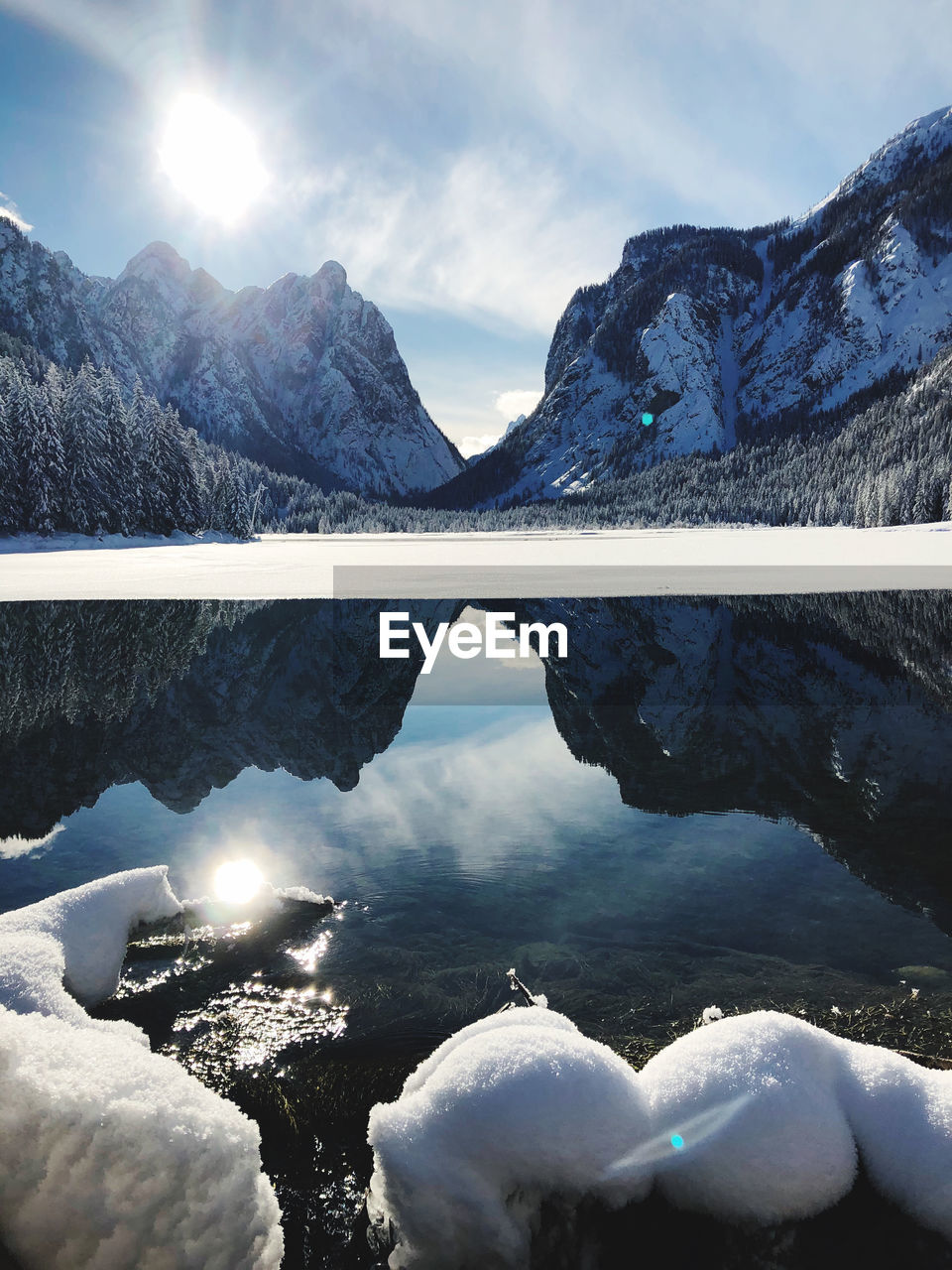 Scenic view of lake by snowcapped mountains against sky