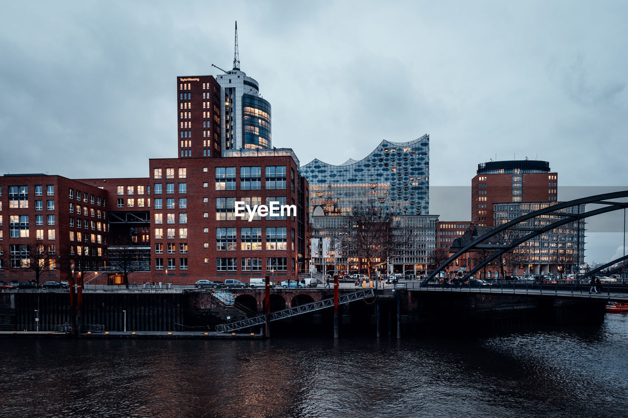 River by buildings in city against sky