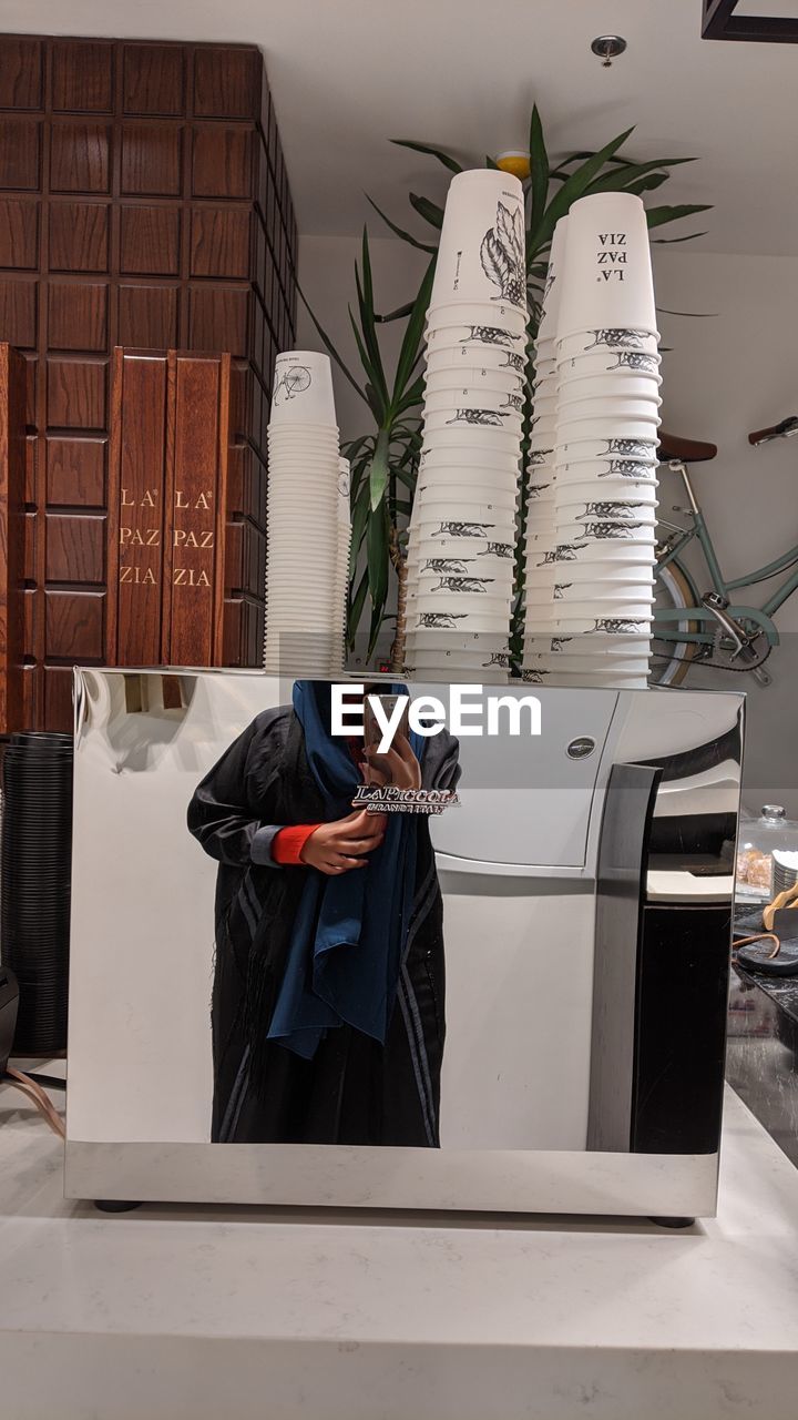 MIDSECTION OF MAN STANDING ON TABLE AT ENTRANCE