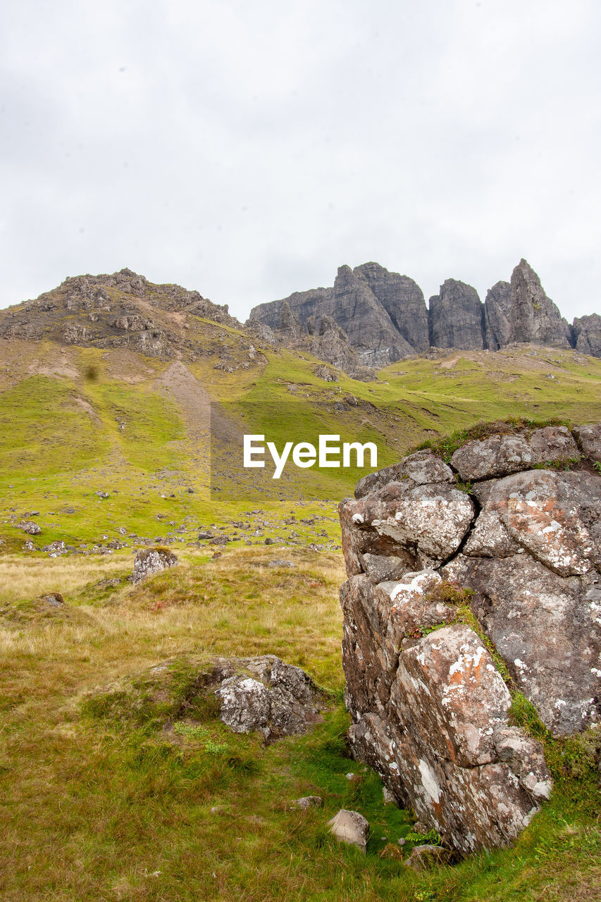 Track leading up to old man of storr, isle of skye. large weathered rock in foreground.