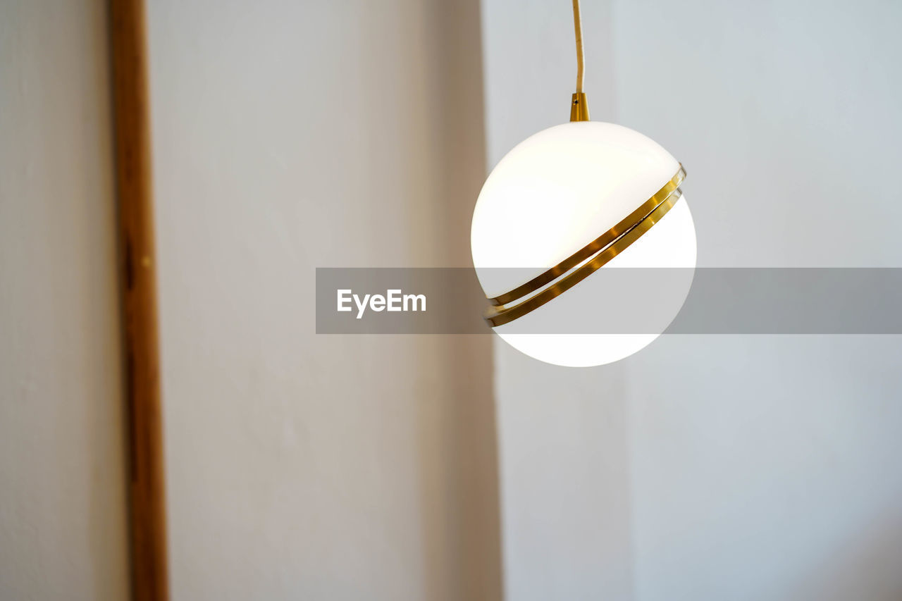 LOW ANGLE VIEW OF LIGHT BULB HANGING ON CEILING