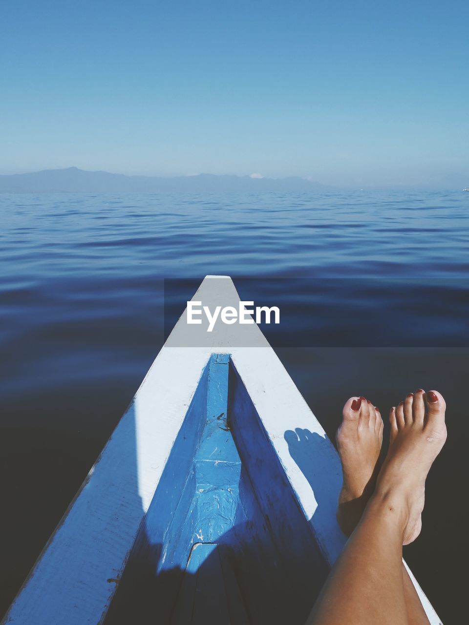 Low section of woman relaxing on boat in sea