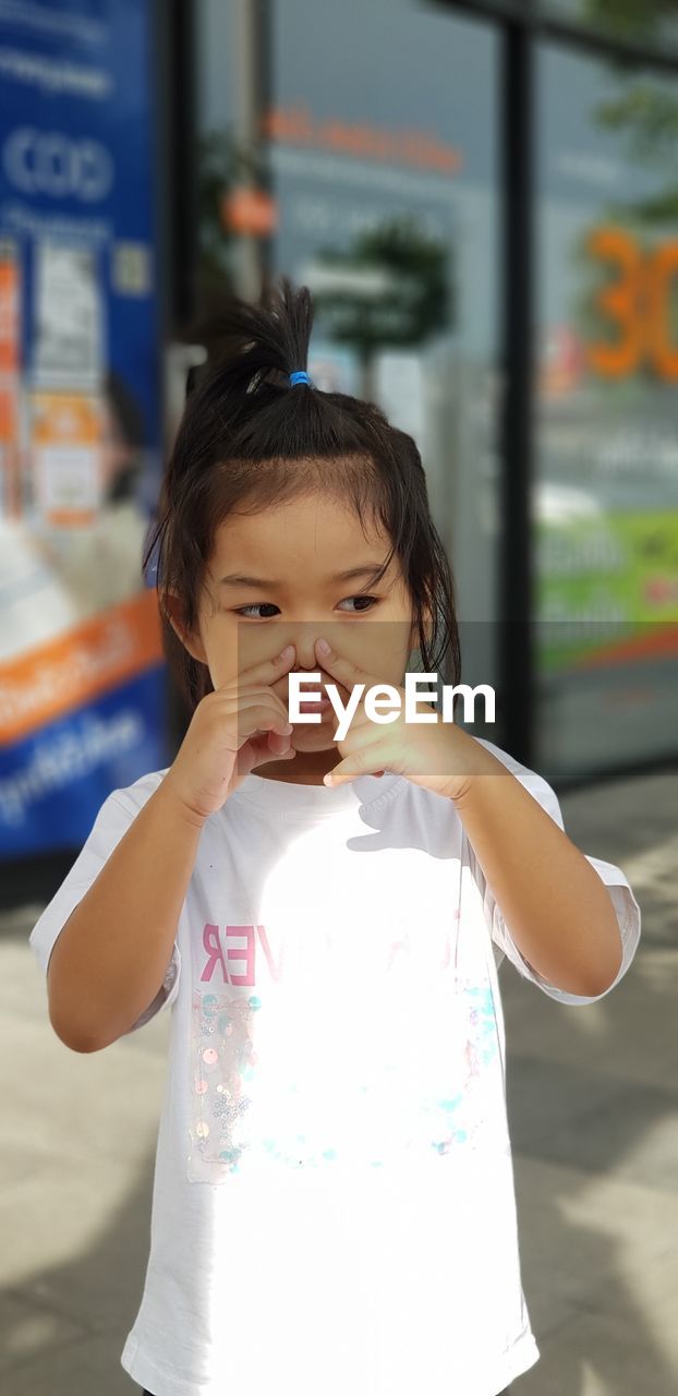 Girl looking away while standing outdoors