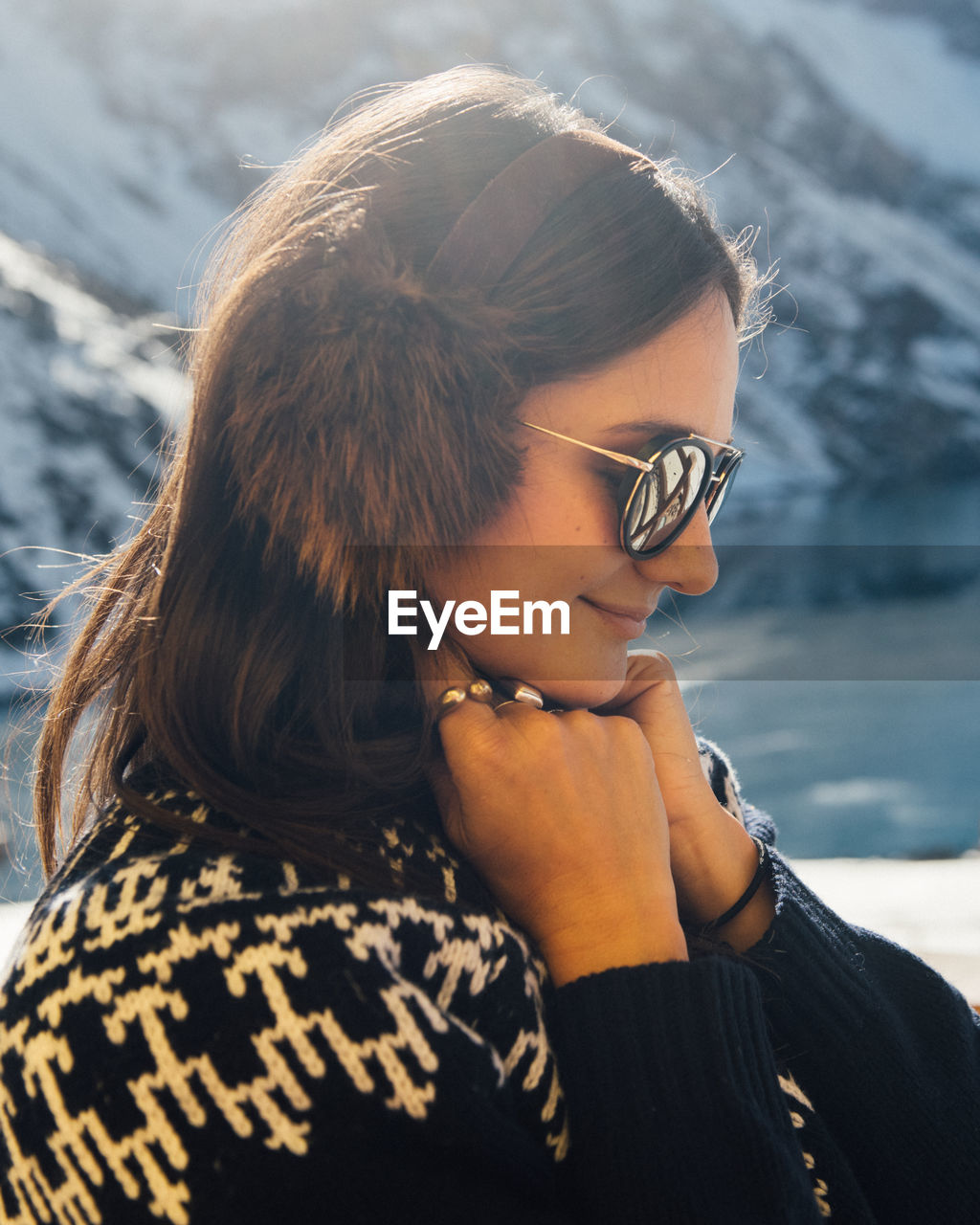 A woman warms up in the sunshine by the mountains in chile.