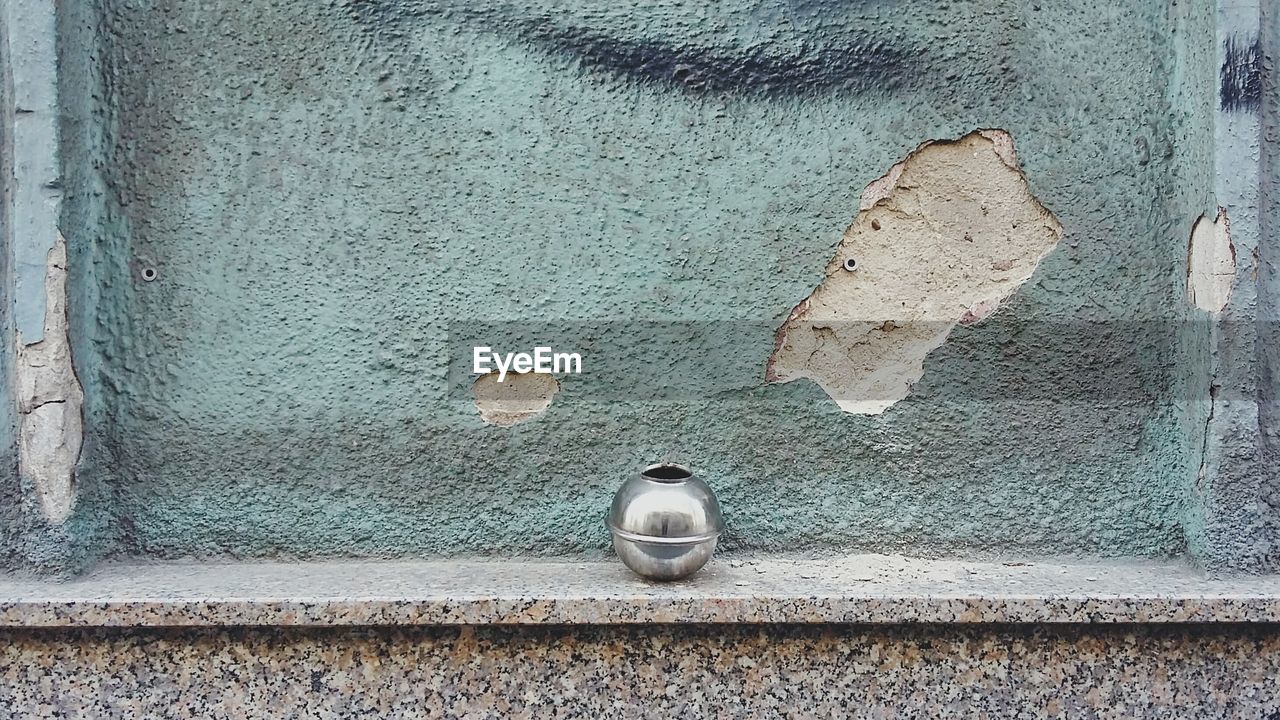 Close-up of metal sphere on retaining wall