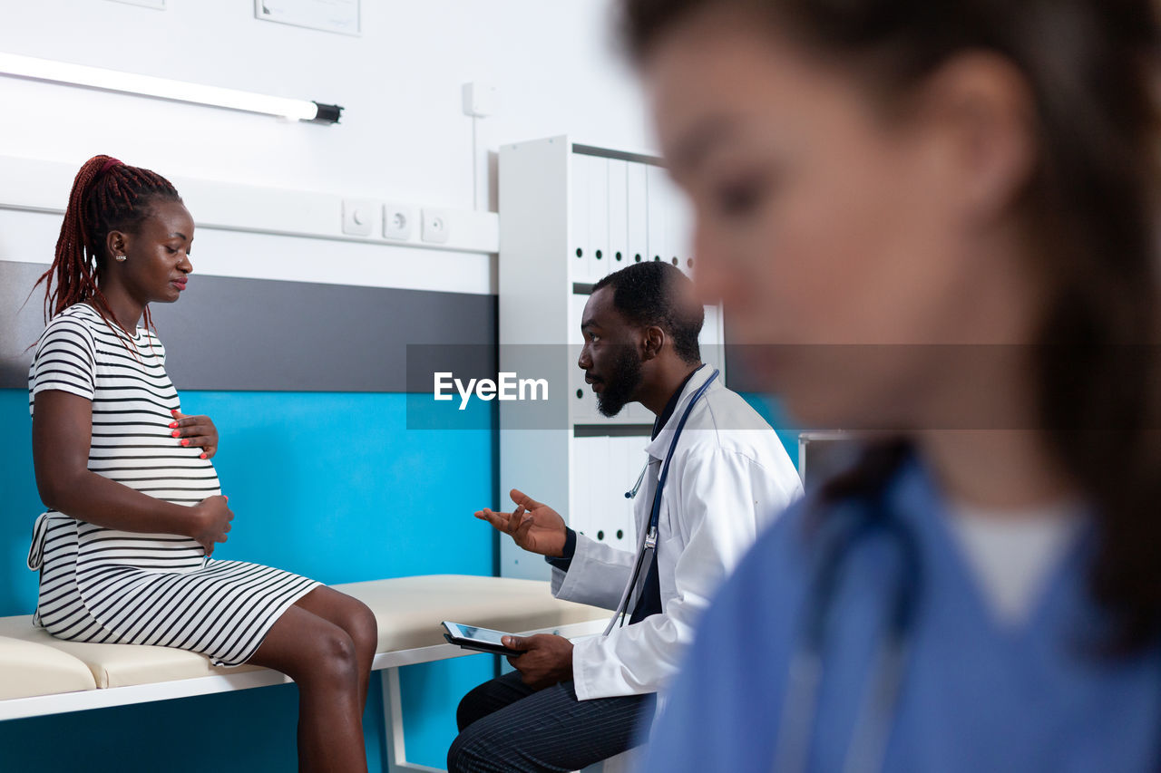 Side view of doctor examining patient at clinic