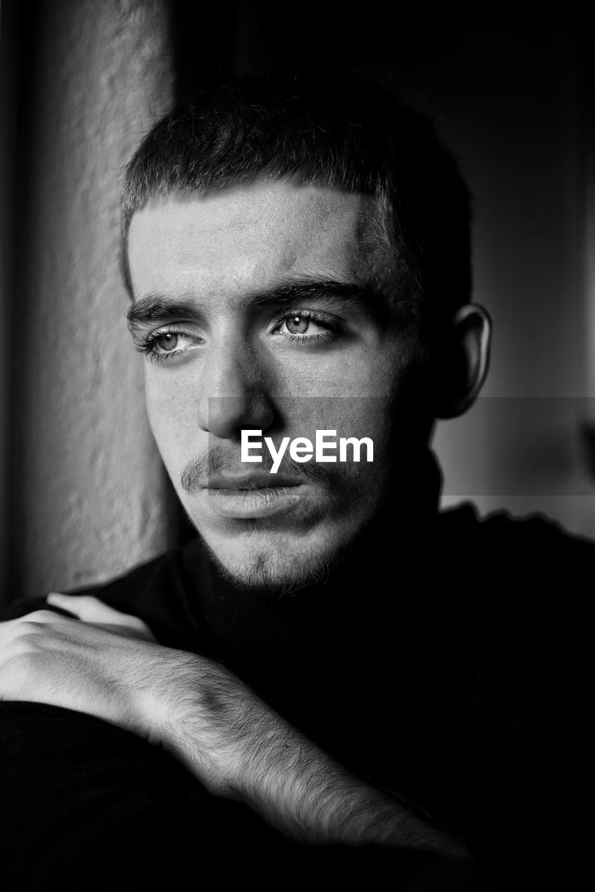 Close-up portrait of young man looking away