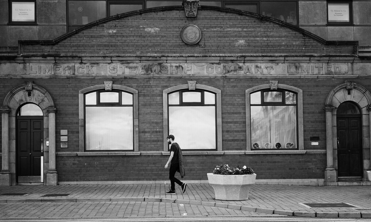 WOMAN WITH UMBRELLA WALKING IN BUILDING