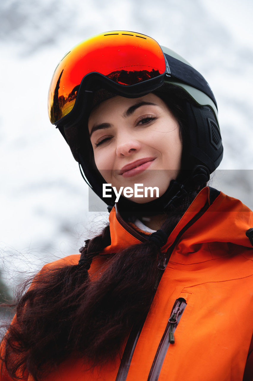 Young woman of caucasian ethnicity looks to the side and smiles, raising her head to the sky